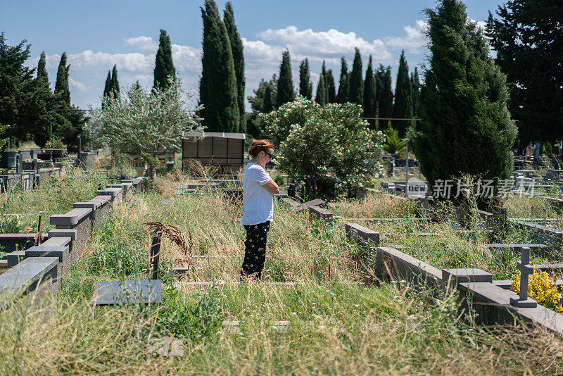这个女人到墓地里父亲的墓前祈祷。