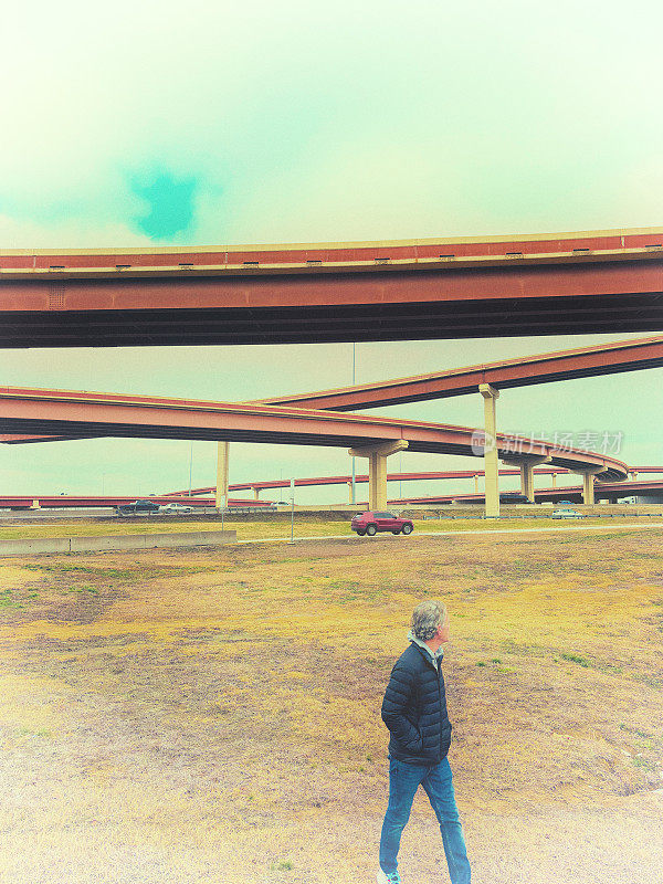 孤独的男人走在高速公路立交桥附近