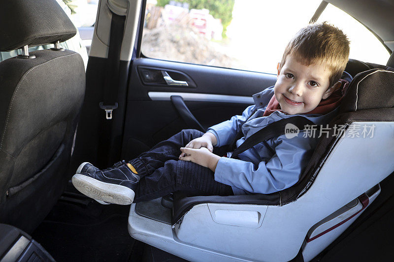 男孩坐在汽车座椅上