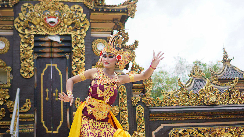 在巴厘岛寺庙背景下，穿着巴厘岛传统服装的巴厘女孩舞者