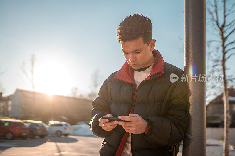 亚洲青少年在城市户外使用智能手机发短信