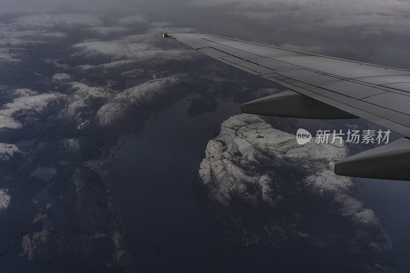 乘客从飞机上俯瞰挪威的峡湾，山上覆盖着积雪