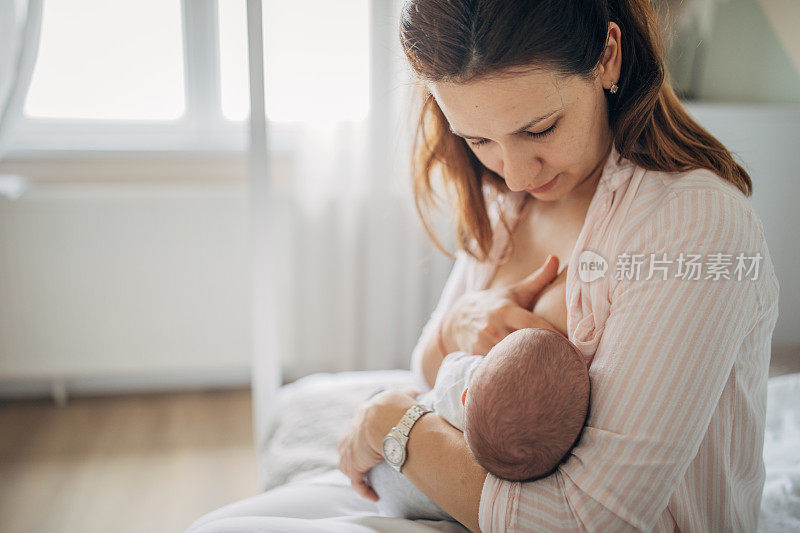 母亲在家里母乳喂养她的男婴