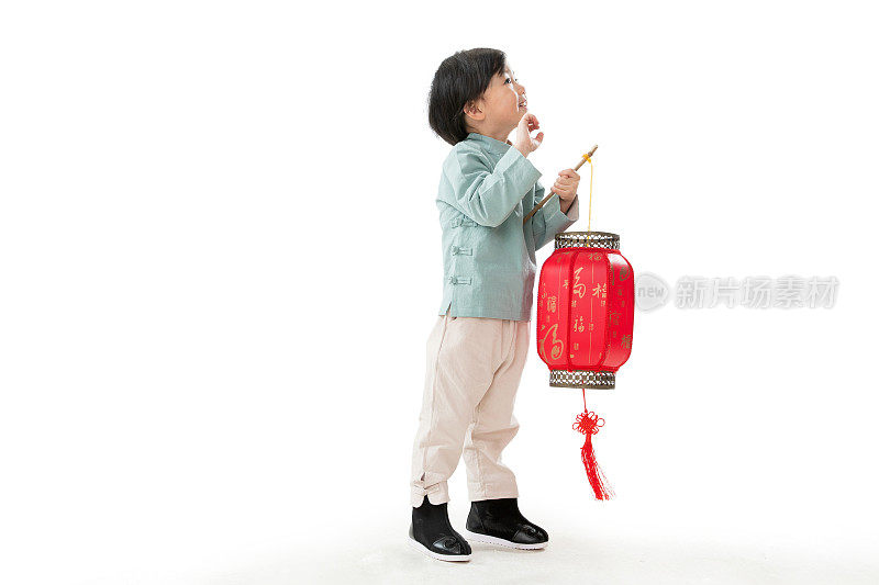 一个小男孩手提红色灯笼庆祝新年