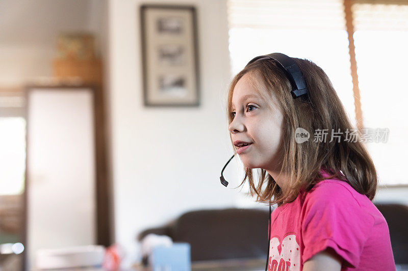 年轻女孩戴着耳机在线游戏