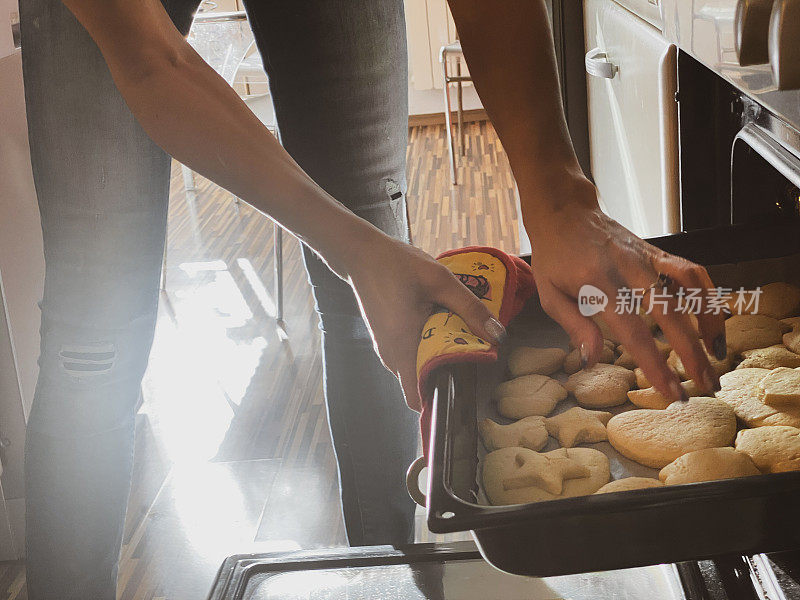 成年妇女检查饼干是否烤过的特写