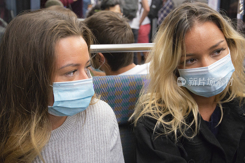 女孩们在地铁上戴着口罩保护自己