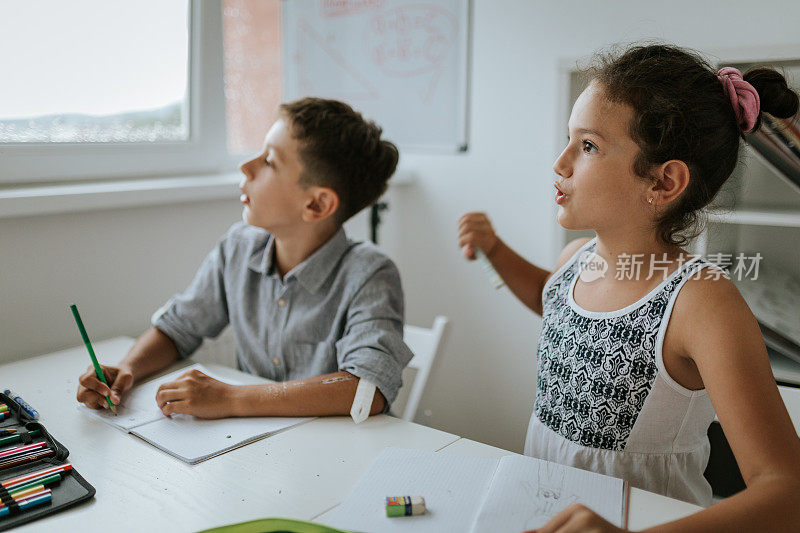一个男孩和一个女孩在做家庭作业时注意力不集中
