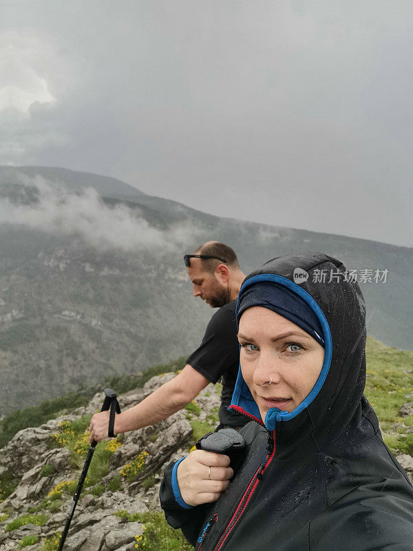 成年男女在恶劣天气中徒步旅行