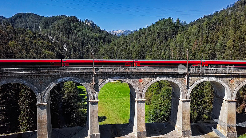 旅客列车乘坐著名的卡尔特里恩高架桥上历史悠久的塞梅林铁路(塞梅林铁路)，下奥地利。