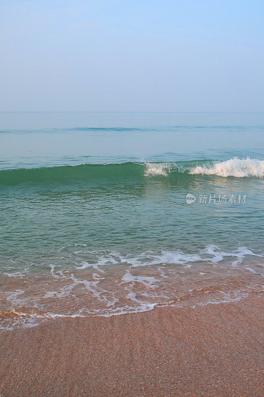 印度夏天的海滩，清澈平静的海浪拍打着海岸海岸线和金色的沙子，海边的潮水，印度果阿