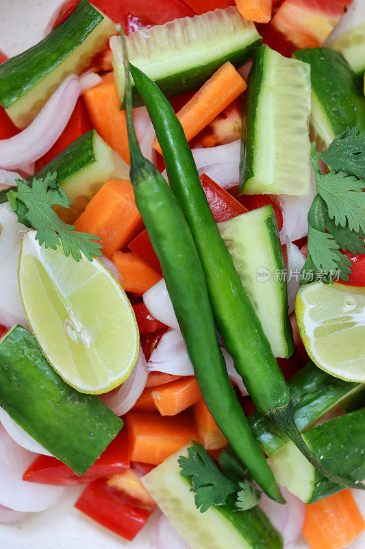 整帧图像的配菜沙拉，包括切碎的蔬菜，黄瓜，西红柿，胡萝卜和红洋葱，高架视野