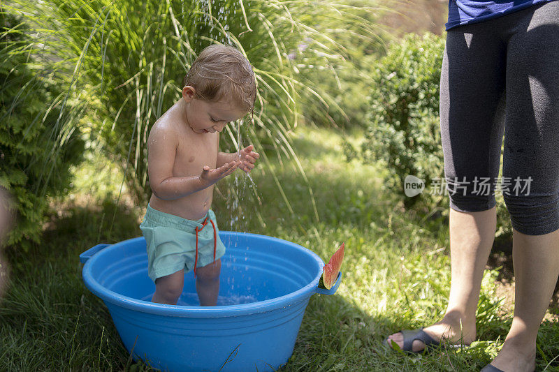 巴拿马的一个小男孩在院子里的浴缸里洗澡