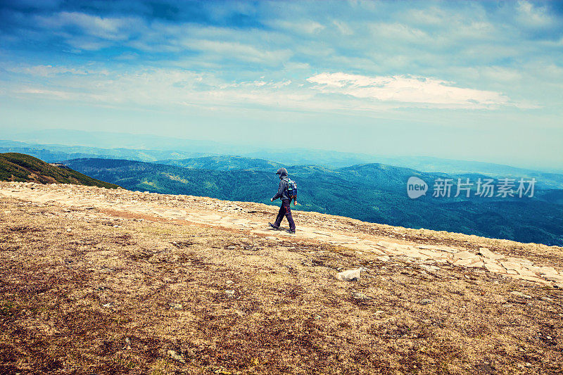 这个男孩在雨天走在山里