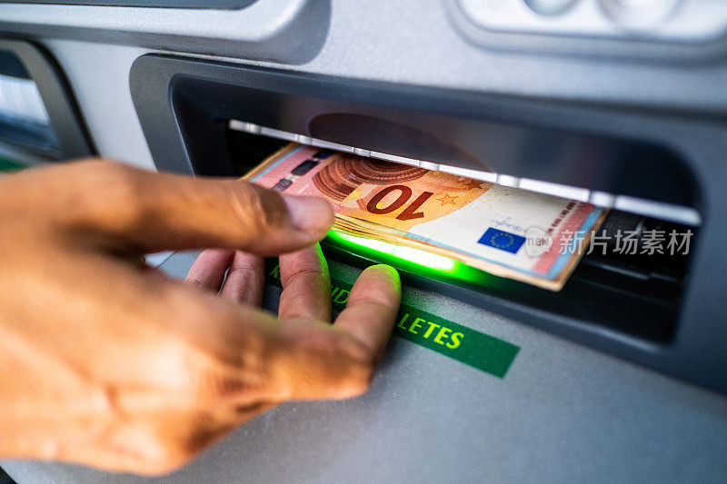 一个人从自动取款机中取出欧元现金的特写镜头
