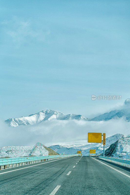 一条高速公路穿过中国新疆的雪山