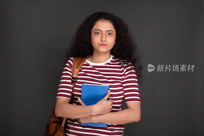 年轻女孩学生的肖像持有笔记本和有背包库存的图像