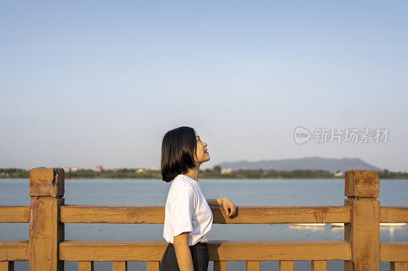 一位亚洲妇女在美丽的河边眺望远方