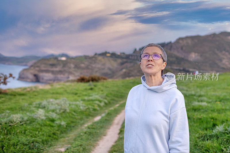 一个女人漫步在海滨的大自然中