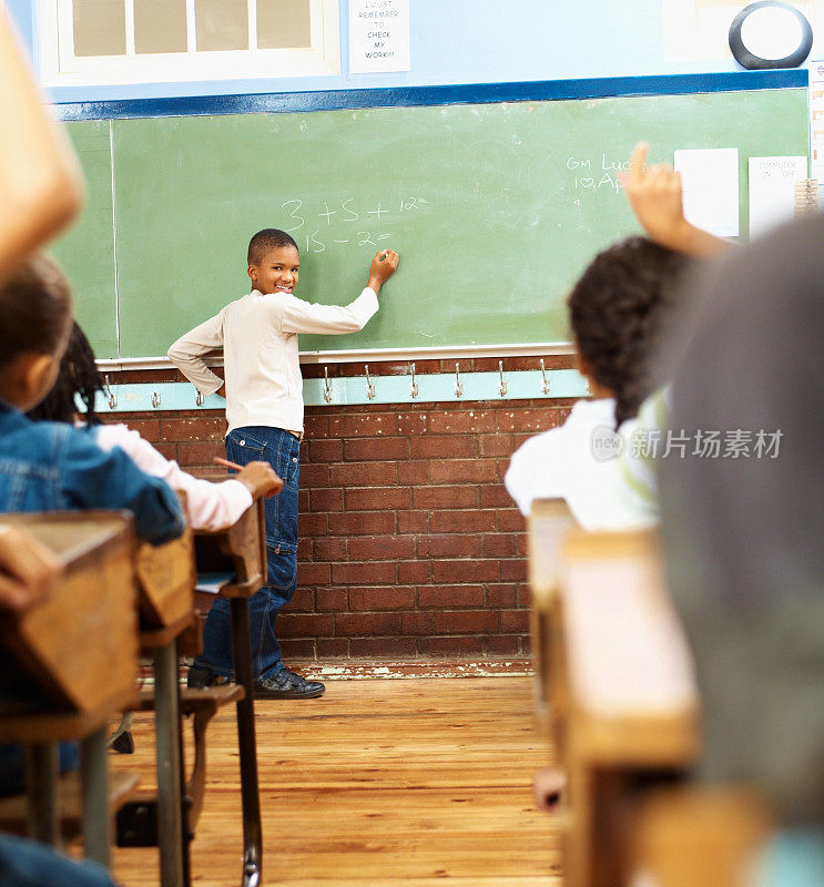 一个小学生在黑板上解数学题