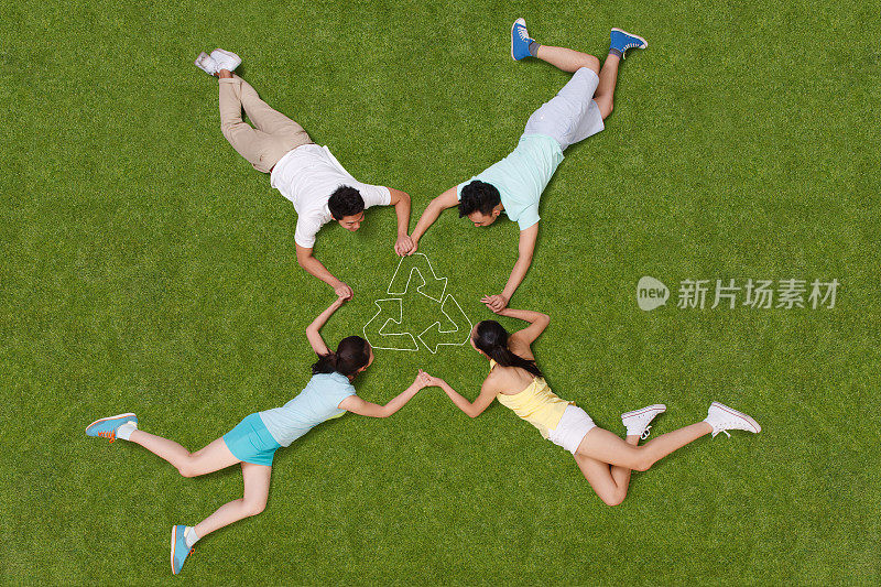 青年男女手牵手躺在草地上