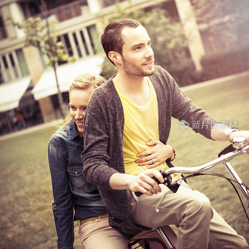 一对年轻夫妇在城市公园里骑车