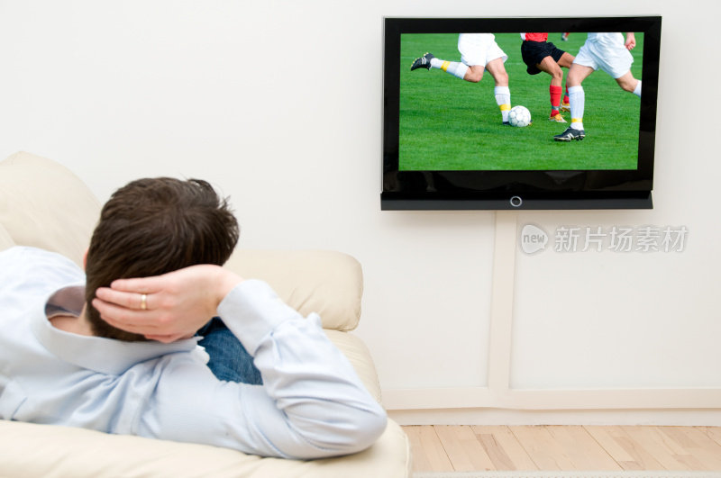 男人在家里通过电视看足球比赛