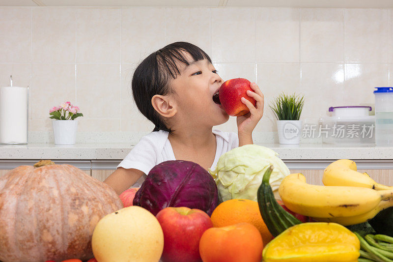 亚洲华人小女孩吃苹果在水果和蔬菜