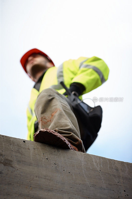 年轻男性建筑工人站在工地上