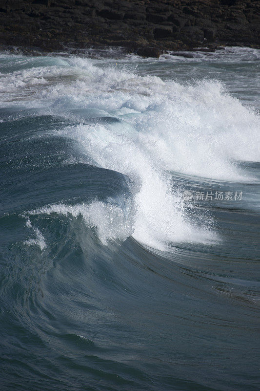 汹涌的蓝色海浪涌向海滩