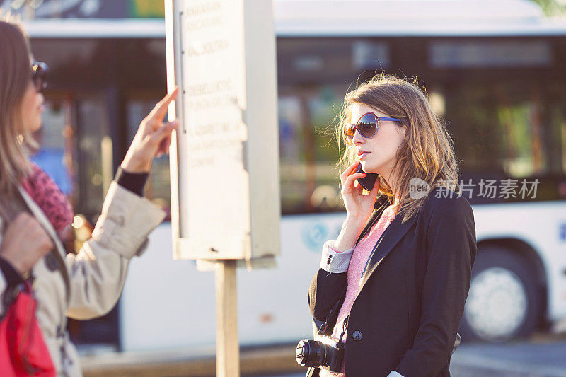一个女人在等公共汽车的时候打电话