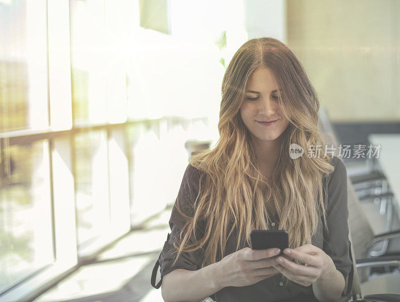 一个女人在会议室里拿着电话看着摄像头