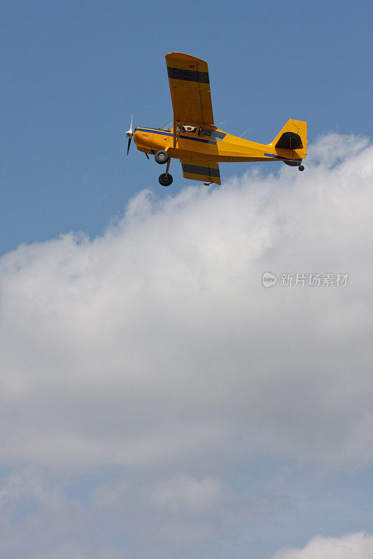 黄色的小飞机在云层上飞行