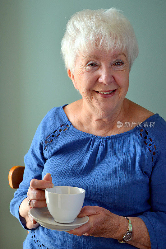 迷人的老女人刚喝完一杯茶