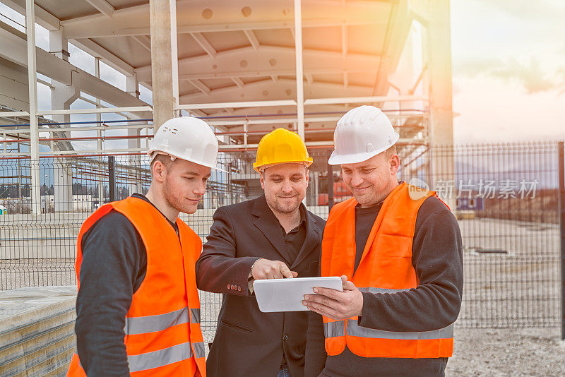 建筑师和建筑工人在平板电脑上看蓝图