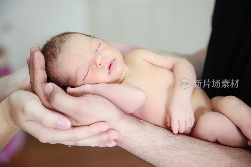 父亲和母亲的手抱着新生婴儿库存图像