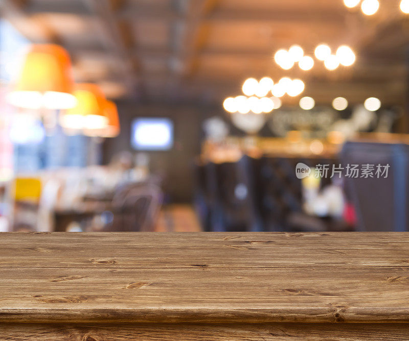 木桌前抽象模糊的餐厅灯光背景