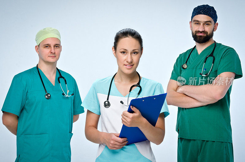 三名身穿绿色手术服，带着语音镜的医生组成的小组。