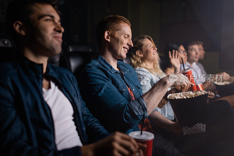 年轻人和朋友在电影院看电影