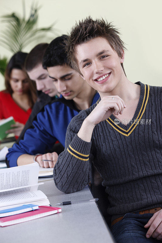 一排快乐的学生在大学教室里学习