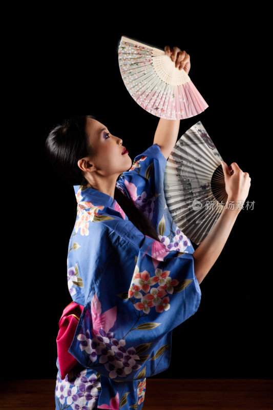 漂亮的日本艺妓拿着一把纸扇