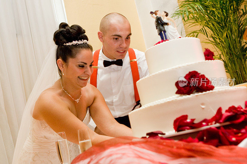 新娘和新郎切三层婚礼蛋糕红白