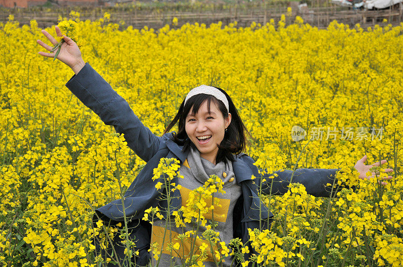 一个中国女孩在菜籽油地里享受