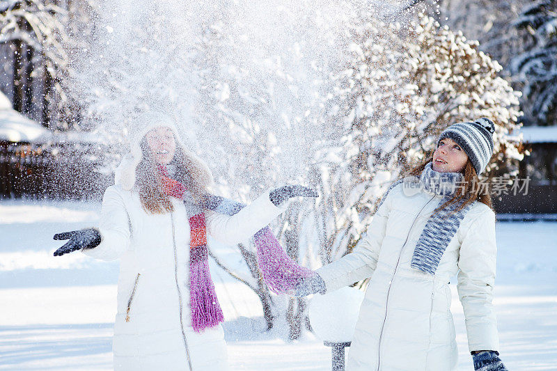 冬天。女孩玩雪球。