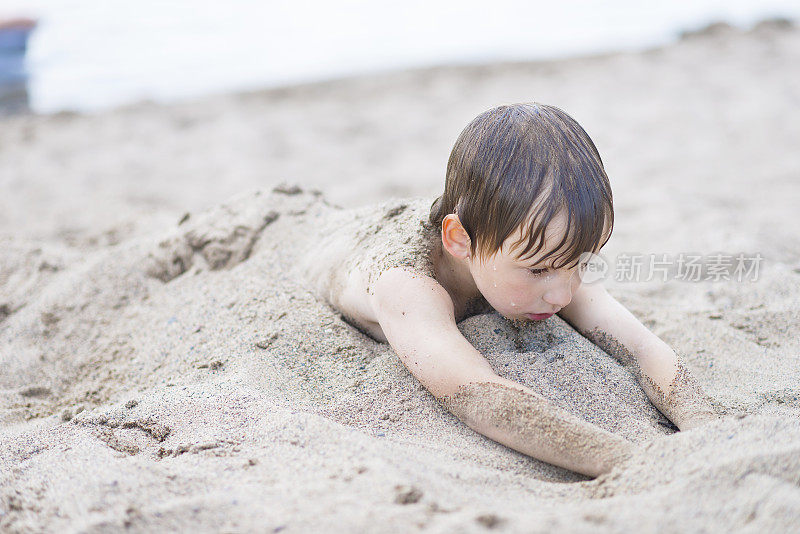 夏天被埋在沙滩上的男孩