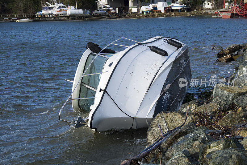 一艘白色的小船侧躺在水面上