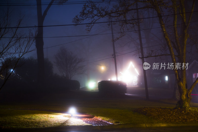 雾蒙蒙的夜晚，小小的城市街道上有灯光的痕迹