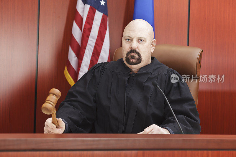 手持木槌的男法官坐在法庭上