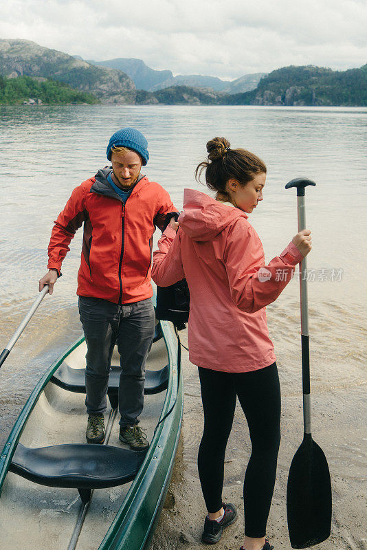 一对夫妇在挪威的湖上划独木舟