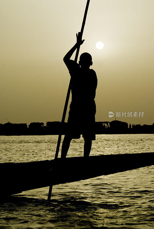 尼日尔河pinasse上的年轻渔夫。